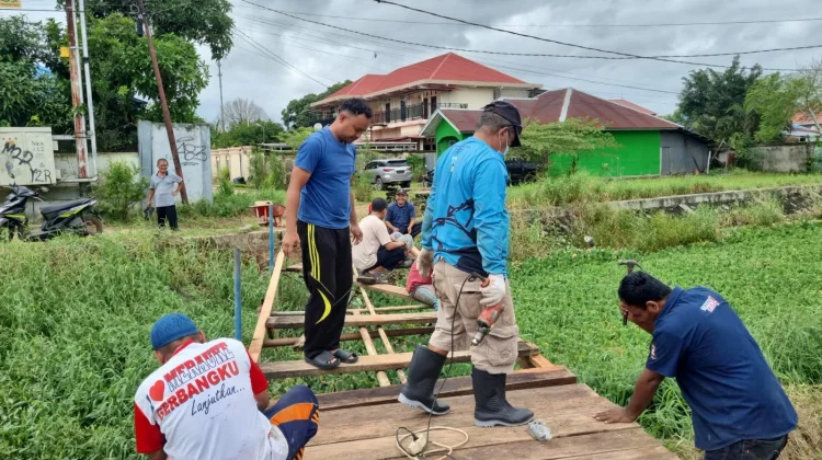 Bhabinkamtibmas dan Warga Gotong Royong Perbaiki Jembatan