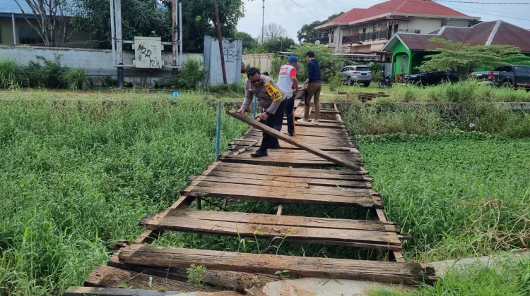 Bhabinkamtibmas dan Warga Gotong Royong Perbaiki Jembatan