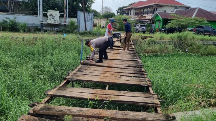 Bhabinkamtibmas dan Warga Gotong Royong Perbaiki Jembatan