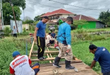 Bhabinkamtibmas dan Warga Gotong Royong Perbaiki Jembatan