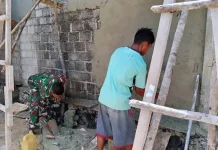 Babinsa Koramil 1503-06/PP Kur Bantu Warga Plester Rumah