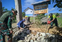 Prajurit TNI Bantu Renovasi Pintu Gerbang Sekolah Perbatasan