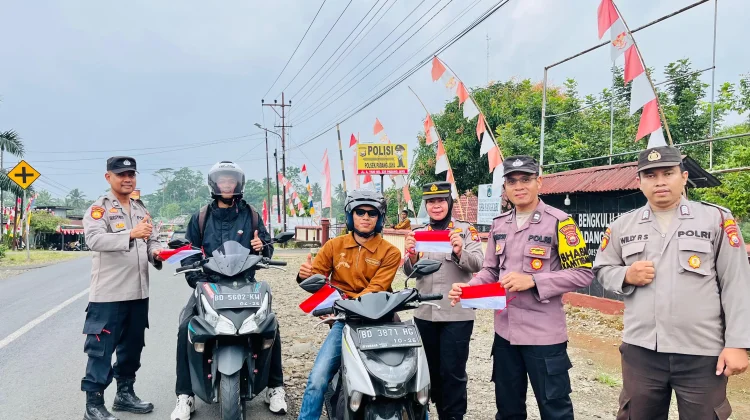 Polsek Padang Jaya Bagikan Bendera Merah Putih kepada Pengguna Jalan