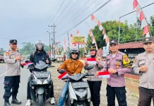 Polsek Padang Jaya Bagikan Bendera Merah Putih kepada Pengguna Jalan