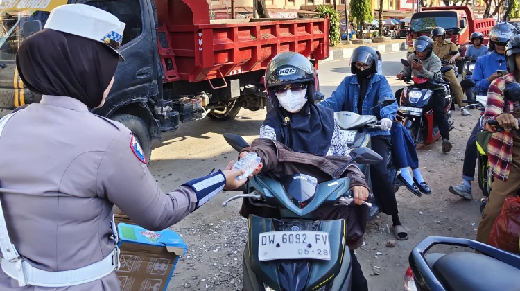 Polwan Satlantas Bone Bagikan Air untuk Pengendara Antre BBM