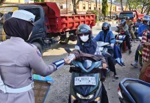 Polwan Satlantas Bone Bagikan Air untuk Pengendara Antre BBM