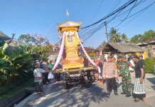 Babinsa Kelating Kawal Prosesi Ngaben Pastikan Lalu Lintas Lancar