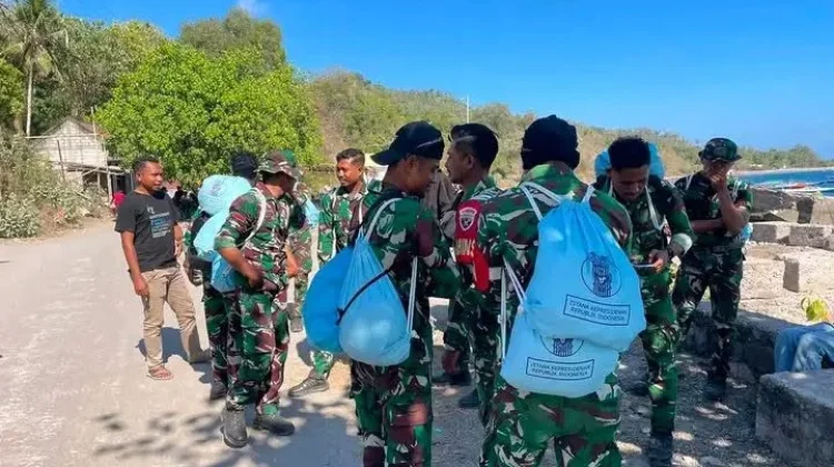 TNI Pikul Bantuan Lewati Medan Sulit Palue
