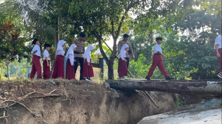 Brimob Polda Gorontalo Bantu Siswa Seberangi Jembatan Kayu Berisiko