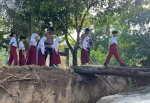 Brimob Polda Gorontalo Bantu Siswa Seberangi Jembatan Kayu Berisiko