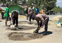Brimob Polda Gorontalo dan Warga Lanjutkan Pengecoran Jalan Rusak di Tibawa