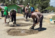 Brimob dan Warga Tibawa Kompak Cor Jalan Rusak