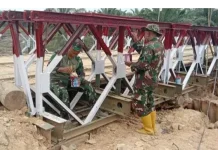 Anggota Koramil 13/Baktiya Lanjutkan Pengecatan Jembatan Belly