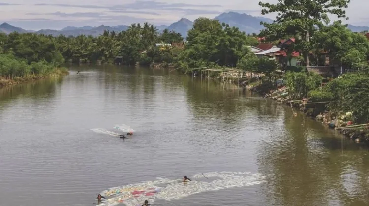 Perempuan Passau Uwai Berenang di Sungai Penuh Sampah  Demi Air Bersih