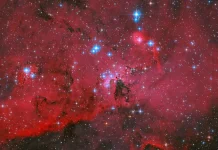 Teleskop Hubble Abadikan Awan Merah Menyala Berhias Bintang Biru