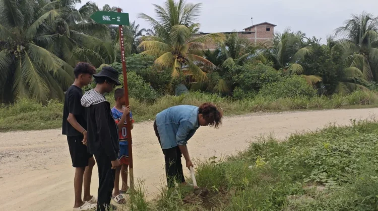 Mahasiswa Kukerta UNRI Desa Teluk Piyai Pesisir Pasang Plang Jalan