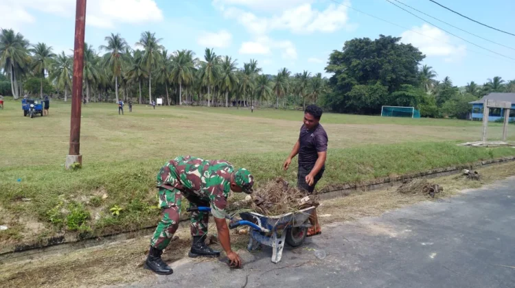 Babinsa Bantu Bersihkan Lapangan
