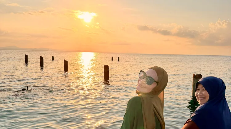 Dua Wisatawan Menikmati Keindahan Sunset di Pulau Senoa