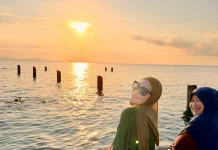 Dua Wisatawan Menikmati Keindahan Sunset di Pulau Senoa