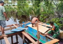 Babinsa Air Mali Bantu Warga Perbaiki Pompong di Pelabuhan