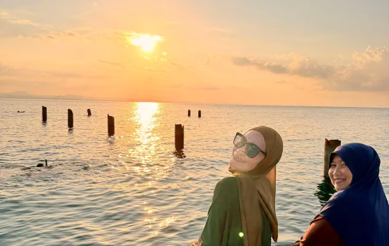 Dua Wisatawan Menikmati Keindahan Sunset di Pulau Senoa