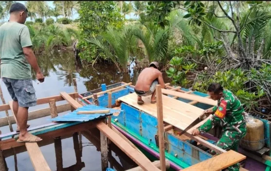 Babinsa Air Mali Bantu Warga Perbaiki Pompong di Pelabuhan