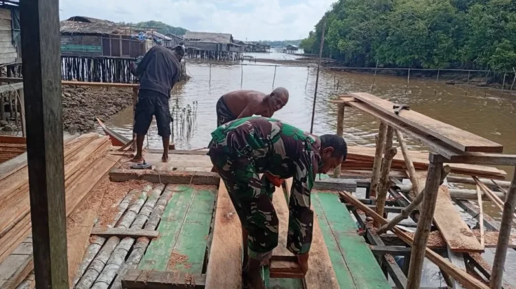 Babinsa Ansus Bantu Warga Pasang Dinding Rumah