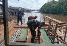 Babinsa Ansus Bantu Warga Pasang Dinding Rumah