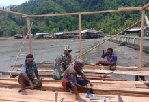 Babinsa Serui Bantu Warga Bangun Rumah di Wadapi