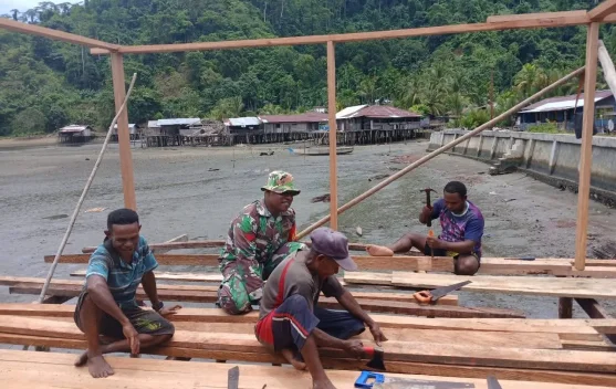 Babinsa Serui Bantu Warga Bangun Rumah di Wadapi