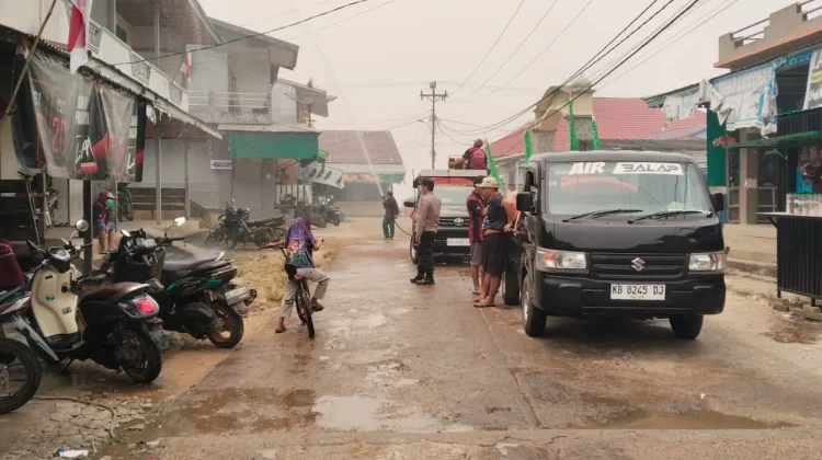 Kabut Asap dan Debu Selimuti Belitang, Polisi Bagikan Masker dan Semprot Jalan