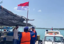 Satpolairud Polres Bintan Bagi-bagi Bendera Merah Putih di Pesisir