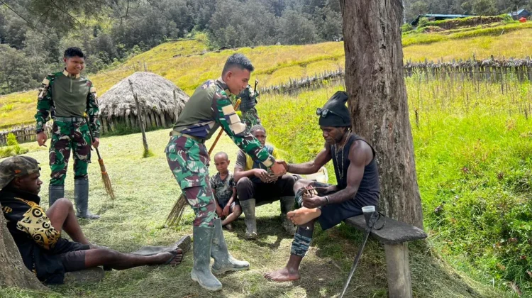 Satgas Yonif 511/DY dan Warga Kampung Tima Gotong Royong Bersihkan Fasilitas Umum
