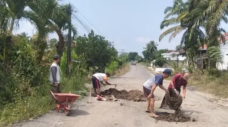 Warga Umpu Bhakti Swadaya Timbun Jalan Berlubang