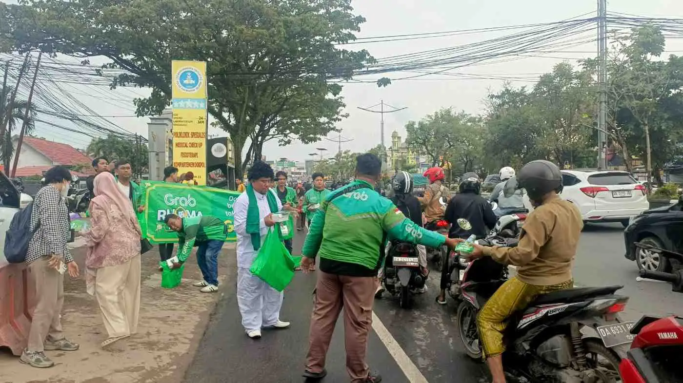 Suasana Komunitas Grab Banjarmasin saat Membagikan Takjil kepada Warga di depan Rumah Sakit Bhayangkara Banjarmasin.