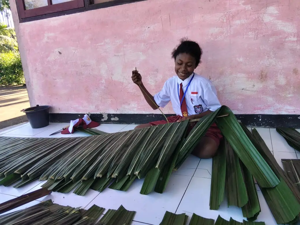 Salah satu siswa kelas vi saat membuat atap dari daun rumbia