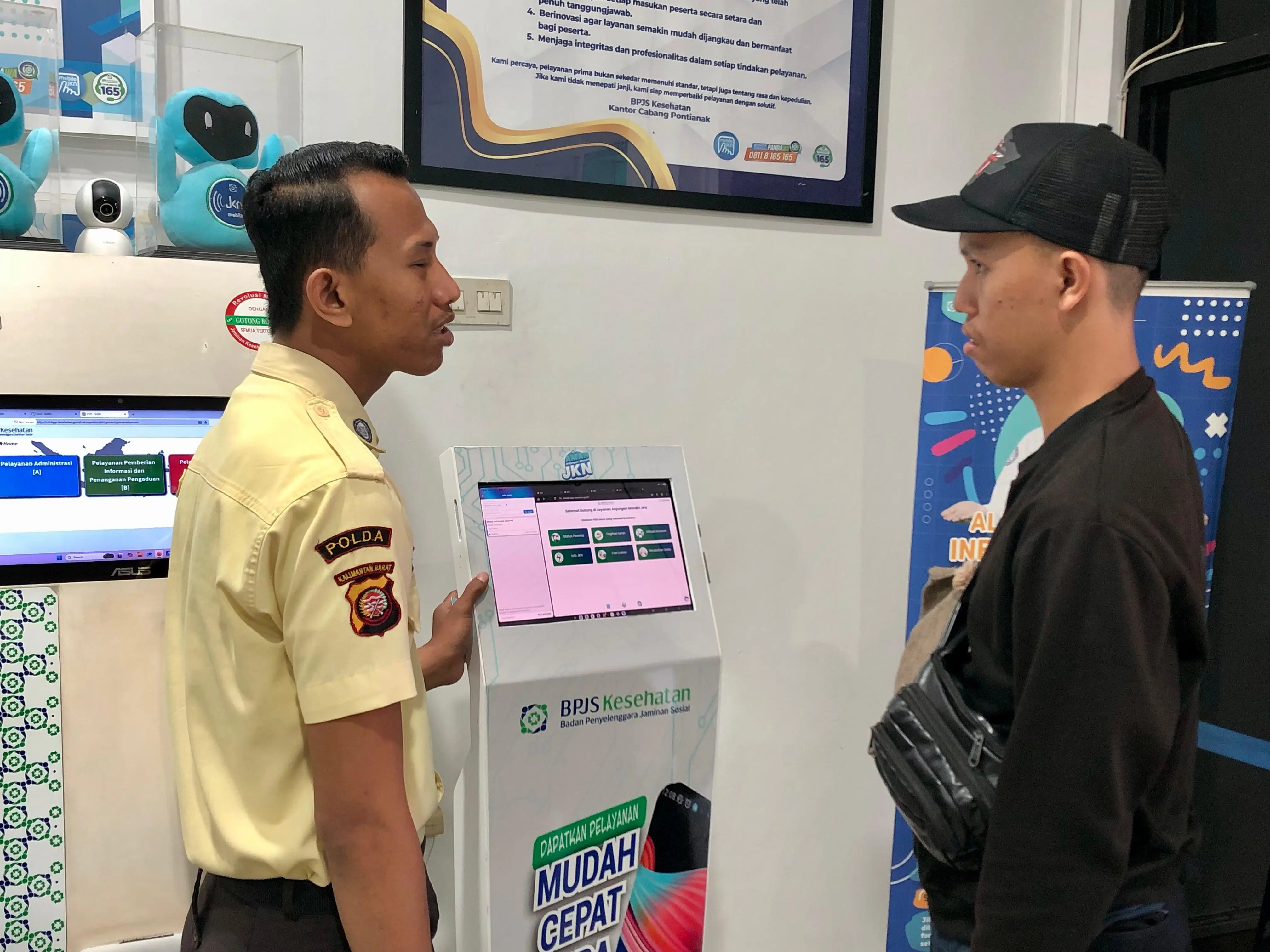 Petugas scurity di kantor BPJS Kesehatan Pontianak memperlihatkan layanan digital kepada warga yang datang. (RRI/Muhammad Rokib)