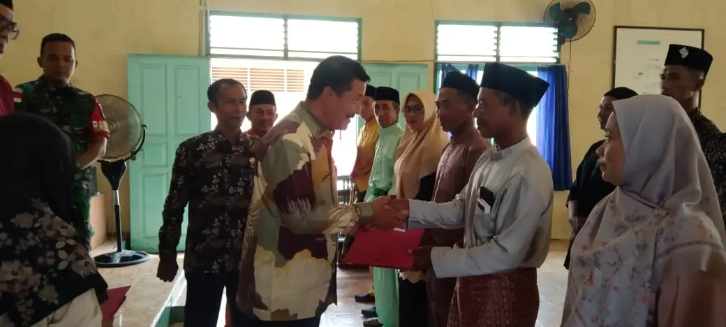 Kepala Bagian Tata Pemerintahan Setda Natuna, Izhar Menyerahkan Surat Keterangan (SK) secara Simbolis kepada RT dan RW yang baru dilantik dan dikukuhkan (Foto: RRI Ranai/ Saleh)
