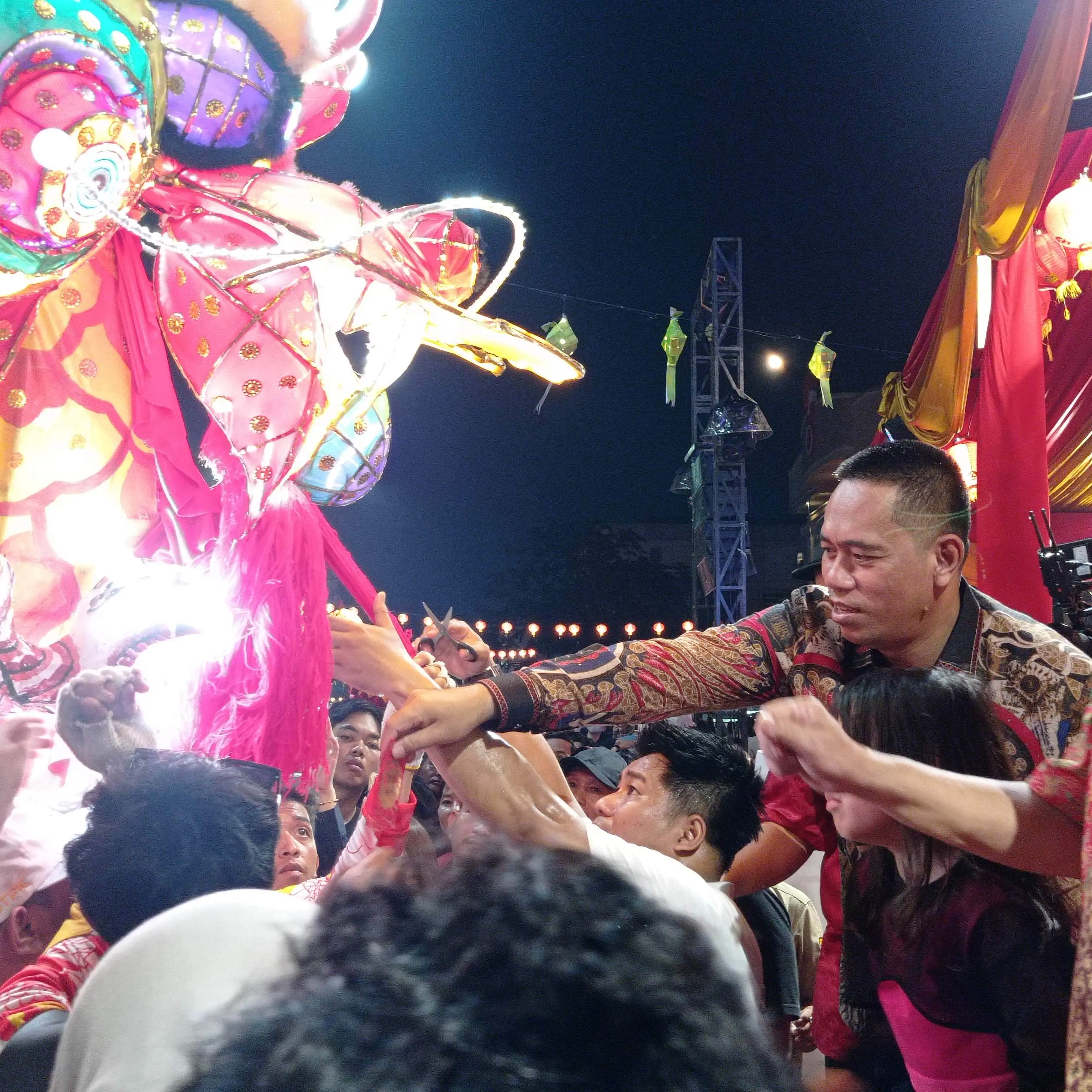 Ketua DPRD Kota Pontianak, Satarudin saat memberikan angpao kepada petugas atraksi naga bersinar. (RRI/Muhammad Rokib)