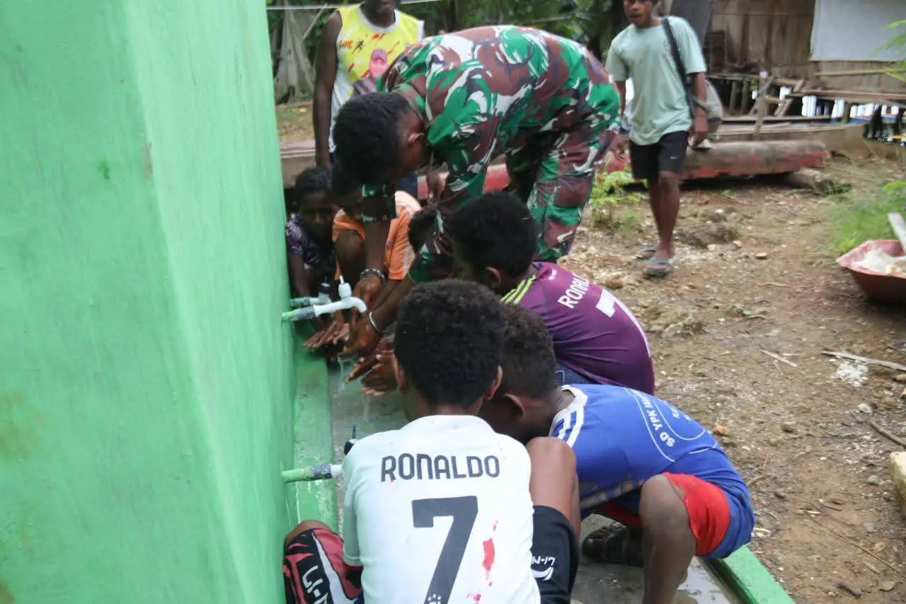 anak2 kampung rembai antusias mencoba bank penampung air bersih yang di bangun pada program TMMD di kampung Rembai (FOTO Satgasa TMMD 127)